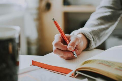 Mano che scrive su un quaderno