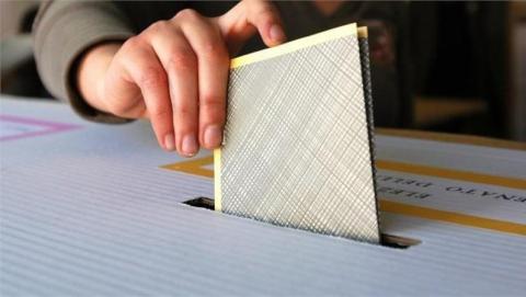 Una mano che inserisce la scheda elettorale nell'urna