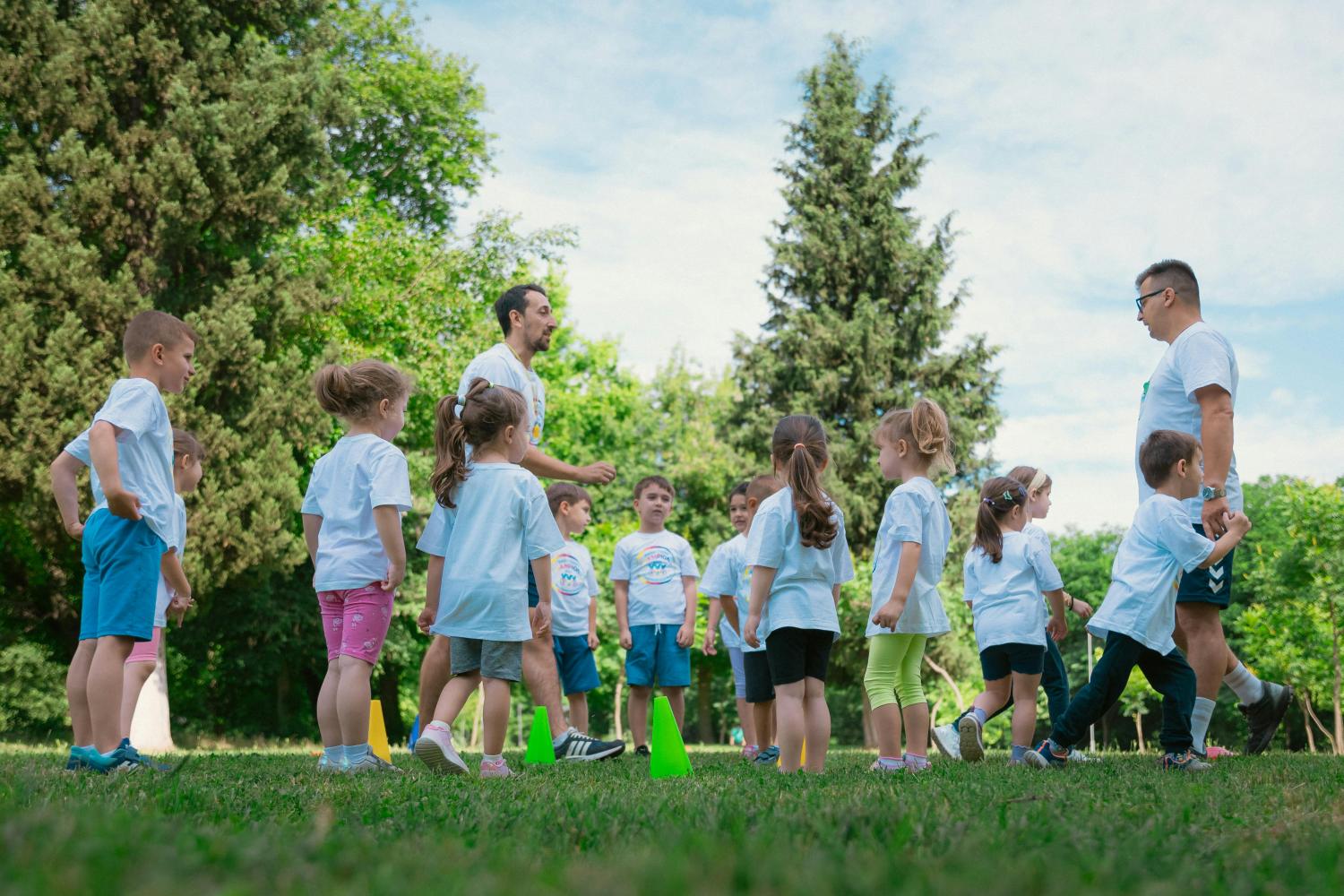 Bambini che giocano sul prato con educatori